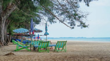 Kumsalda ve mavi gökyüzünde branda sandalye. Tayland 'ın Rayoung bölgesindeki plaj tuvalleri. Kanvas katlanır yatak Sahilde parlak bir gökyüzünde