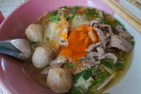 Thai Boat noodles in thicken soup added blood with Pork balls, Sliced beef and liver serve with basil and crispy fried pork skin. Thai noodle style with pork, Rice noodle soup with Stewed pork, meatball and pork liver in blood soup. - Asian food styl