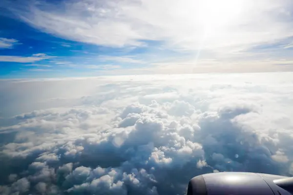 White clouds on blue sky background close up, cumulus clouds high in azure skies, beautiful aerial cloudscape view from above, sunny heaven landscape, bright cloudy sky view from airplane.