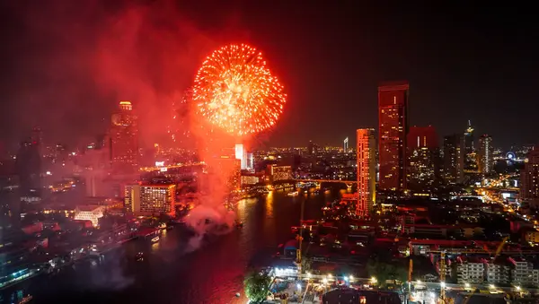 Firework lighting in Bangkok cityscape background, Night view and firework. Celebration fireworks exploding of New year's day or Christmas celebration day in downtown district at Chao Phraya River, Thailand.