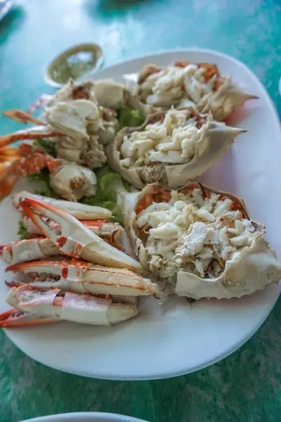 Steamed crabs peeled off and crab meat put it on a plate. Ready to Eat Blue Swimmer Crab, crabmeat steamed served with spicy seafood dip in a white plate decorated with crab shell.