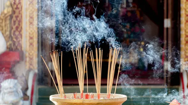 Incense sticks in the pot to pay homage to the sacred. Incense burning for prayer in a Temple. Incense-stick and smoke from incense burning in Thailand.