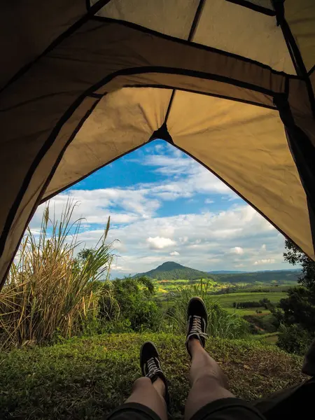 Mountain hiker and camper. Person resting in a camping tent, at Khao Takhian Ngo, Thailand. Adventure and freedom. Beautiful mountain view form the tent in winter.