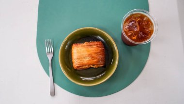 Kahvaltı manzarası bir sürü çikolatalı kruvasan ve kafenin arka planında bir fincan kahve. Restoran menüleri için mükemmel. Yumuşak ışıklar, rahat ve rahatlatıcı bir atmosfer yaratır.