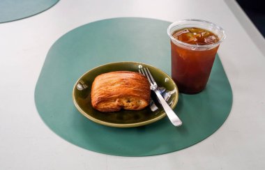 Kahvaltı manzarası bir sürü çikolatalı kruvasan ve kafenin arka planında bir fincan kahve. Restoran menüleri için mükemmel. Yumuşak ışıklar, rahat ve rahatlatıcı bir atmosfer yaratır.