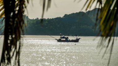 Açık denizde yüzen küçük bir balıkçı teknesi, yakın plan. Yattan bir manzara. Boş zaman aktivitesi, spor ve eğlence, gıda endüstrisi, geleneksel zanaat, çevresel hasar kavramları. Gölde yüzen bir balıkçı teknesi. Turkuaz mavi deniz..