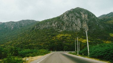 Güzel bir yol ve dağ manzarası yeşil tarlalarda asfalt yol ve yaz günü mavi gökyüzünde bulutlar. Tayland 'da güzel çayır yolu.