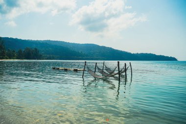 Parlak güneşli bir yaz gününde tropik cennet okyanus sahilinde romantik bir hamak. Yaz tatili ya da tatil geçmişi. Tropikal beyaz sahildeki saman hamağının manzarası