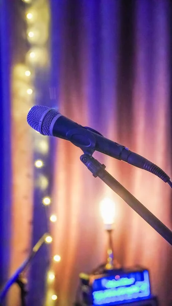 Microphone on stage. microphone on stand with colorful light bokeh background in conference hall. Close up of microphone on stage in audience room blur background.