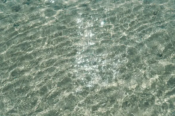 Blue ripped sea water as swimming pool Crystal clear ocean lagoon bay turquoise blue azure water surface closeup natural. close up of water of the ocean with sun shine sparkling.