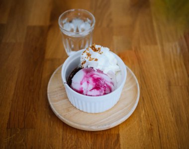 Dondurma, yabanmersini, ahududu ve yaban mersinli yaz tatlısı. Masada yüksek açılı yoğurt ve yaban mersinli dondurma var..