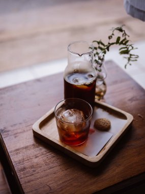 El yapımı kahve soğuk espresso buzlu kahve ve buz küpleri. Sabahları buzlu, soğuk bir kahve. Hafif, ahşap masa arkası..