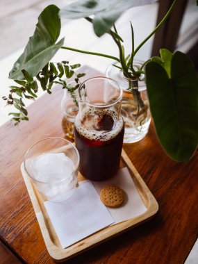 El yapımı kahve soğuk espresso buzlu kahve ve buz küpleri. Sabahları buzlu, soğuk bir kahve. Hafif, ahşap masa arkası..