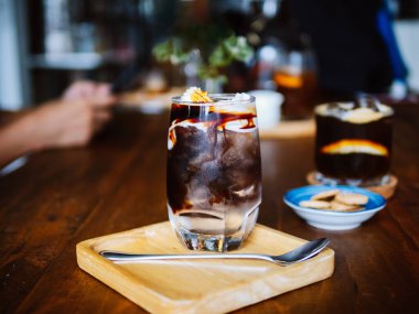 Buzlu Amerikan hindistancevizi. Temiz bir bardak buzlu Americano taze hindistan cevizi suyu ve masada hindistan cevizi eti, soğuk bir yaz içeceği ve ev kahvesi konsepti..