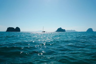 Su güneşi duvar kağıtlarının arka plan dokusunu yakar. Okyanus dalgalarında parlayan güneş ışığı. Scintillate deniz yüzeyi ve yaz ve akşam kayalık kıyı şeridi.