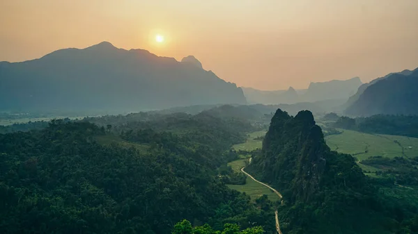 Stunning view of some tourists taking pictures at the beautiful panorama from the Nam Xay viewpoint in Vang Vieng, Laos.
