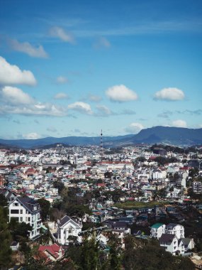 Vietnam 'daki DALAT şehrinin insansız hava aracından yüksek açılı görüntüsü. Çok renkli evleri ve dükkanları olan bir şehre bakın. Güneşli bir günde Dalat 'ın dışındaki Vietnam' ın orta dağlık kesimlerinde tarım arazisi. Ana ekinler kahve, çiçekler, meyve ve sebzelerdir.. 