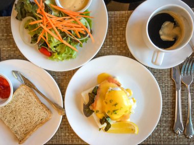 Table full of various fresh food in luxury modern restaurant. Delicious dishes, cold cuts, salmon, omelette, pastries, juices, cheese. Delicious and lavish breakfast or morning meal in high-end hotel