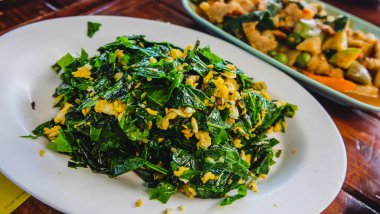 Güney Tayland Menüsü Karıştırılmış Malindjo Yumurtalı Yapraklar (Tayland adı Bai Liang Pad Kai). Kızarmış Pak Liang, melindjo ya da baegu yapraklarını yumurta ile karıştırın.