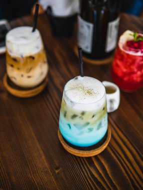 Kahveli mavi içecek, ahşap arka plan. Asgari düzeyde. Köpüklü mavi içecek.