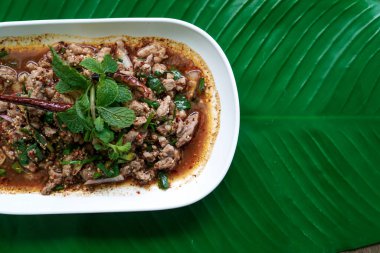 Muz yaprağında baharatlı ördek kıymalı salata. Tayland yerel yemek tarifi laboratuvarı Ped. Larb Ped, Laab Ped, Tayland yemeği, acı biberli baharatlı ördek salatası, dilimlenmiş kokulu ve nane yapraklı.