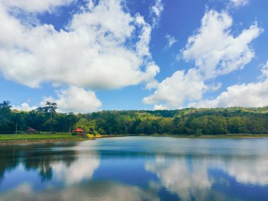 Berrak mavi gökyüzü ve tüylü beyaz bulutları olan el değmemiş bir göl manzarası. Maceralar Kamp Turizmi ve Çadır. Jedkod Pongkonsao, Saraburi, Tayland 'da kamp yapmak için güzel bir göl..