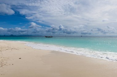 Sakin bir sahil, berrak su, yumuşak dalgalar ve bulutlu güneşli bir gökyüzü. Ufukta tropik su ve kümülüs bulutları görünüyor, Tayland. Yazın güneşli bir günde mavi gökyüzü olan Ocean Beach.