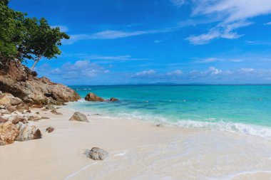 Sakin bir sahil, berrak su, yumuşak dalgalar ve bulutlu güneşli bir gökyüzü. Ufukta tropik su ve kümülüs bulutları görünüyor, Tayland. Yazın güneşli bir günde mavi gökyüzü olan Ocean Beach.