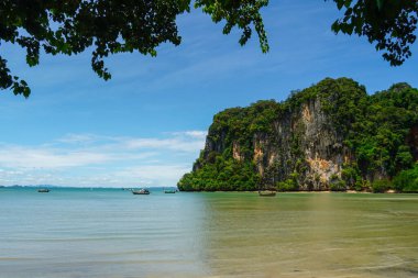 Tayland 'da uzun kuyruk tekneleri (Railay plajı). Kireçtaşı kayalıkları ve kristal berrak suyu olan güzel sahillerde tekneler..