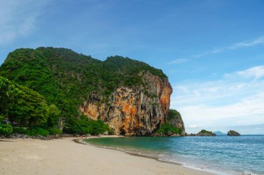 Güzel Railay Sahili ve Krabi, Tayland. Railay Plajı Krabi Tayland, Tayland 'da geleneksel uzun teknesi ve bulutlu gökyüzü olan huzurlu Railay Krabi' nin tropikal plajı.