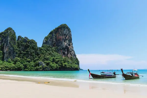 Tayland 'da uzun kuyruk tekneleri (Railay plajı). Kireçtaşı kayalıkları ve kristal berrak suyu olan güzel sahillerde tekneler..