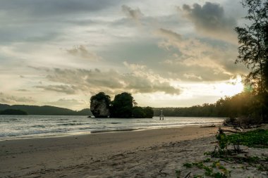 Sahilde gün batımı. Palmiye ağaçları günbatımı arka planı. Dalgalar, turuncu, pembe ve mor güneşli gökyüzü. Muhteşem ada palmiyeleri plaj arka planı. Sun Resort Tatili. Tayland doğası gün batımı manzarası