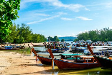 Tayland, Krabi 'deki Nopparat Thara sahilinde ve rıhtımda uzun bir tekne tersanesi. Tekne istasyonu ve yerel otantik tekneler dramatik bulutların altında gökyüzünde.