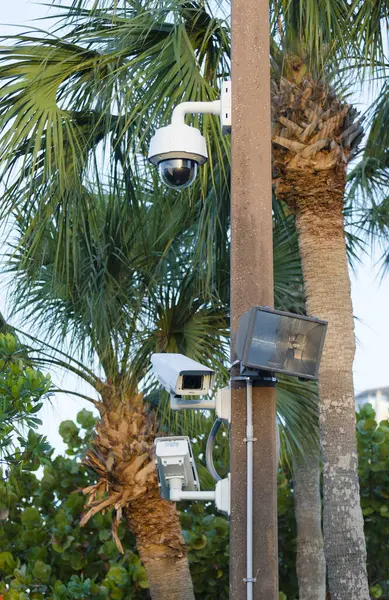 Security cameras and exterior light on pole in Florida used to watch