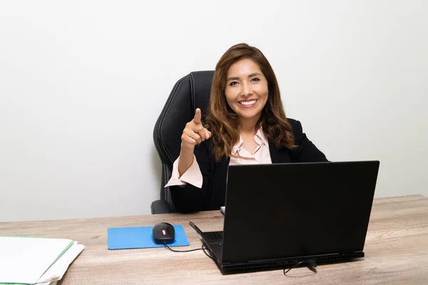 Woman works in human resources sitting in the office pointing her finger at the camera