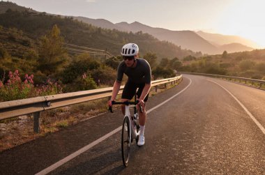 Erkek bisikletçi, çakıllı bisikletinin tepesindeki zorlu araziyi fethediyor. Bisiklet ve miğfer takan bisikletçi, dağlarda çok sıkı çalışıyor. Güzel motivasyon görüntüsü.