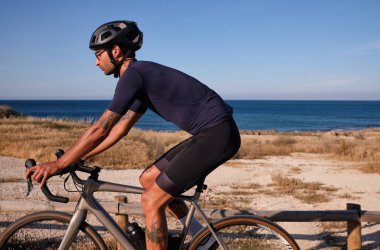 Denize yakın bisiklet süren profesyonel bir bisikletçi. İspanyol bisiklet tatili. Motivasyon imajı. Triatlon konsepti. Xabia, Alicante, İspanya