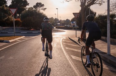 Gün batımında dağlarda bisiklet sürerken bisiklet grubu eğitimine yakından bak. Rekabet için antrenman. Açık arazi yolunda bisiklet antrenmanı. İspanya.