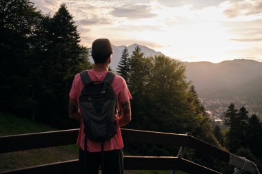 Yürüyüşçülerin gün batımına hayran kaldıkları arka manzara. Gün batımında ormanlı dağların ve tepelerin doğa manzarası. Dağ günbatımı izleyicisi..