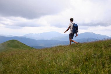 Baiului Dağları izleri. Sırt çantalı bir gezgin dağda yürüyüş yapıyor. Doğası gereği seyahat ediyor. Orta yaşlı bir adamın dağlarda yürüyüş yaparken çekilmiş dikiz aynasından. Bucegi doğal parkı.