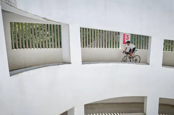 stock image Professional cyclist riding on an empty city parking lot.Sports motivation