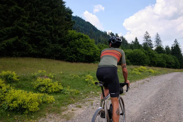 Gravel biking. Male cyclist practicing on gravel road. Cycling exploration adventure.
