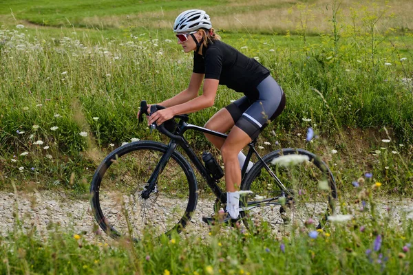 Подходит Спортсменка Велосипедной Одежде Защитном Шлеме Черном Велосипеде Зеленой Травой — стоковое фото