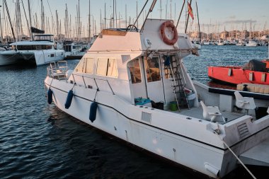 Gün batımında yat parkında. Günbatımında yatları olan deniz koyunda. Demirli yatlar. Marina, iskele. Gün batımında gemi direklerinin deniz suyuna yansıması. Torrevieja, Alicante, İspanya