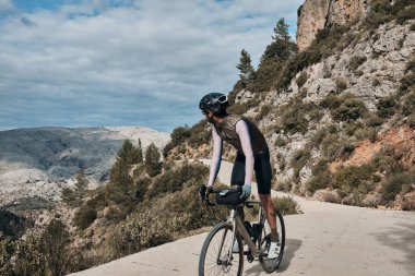 Bisiklet ve kask takan bir bisikletçi. Dağlarda bisiklet süren bir adam. Erkek bisikletçi dağlarda bisiklet sürüyor. Serra de Bernia, Alicante, İspanya