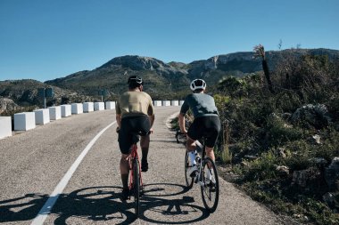 Vall d 'Ebo geçitlerinde iki bisikletçi eğitimi. İspanyol dağlarında bisiklet sürüyor. Kasklı bisikletçiler ve bisiklet sürücüleri Vall d' Ebo geçitlerini fethediyor..