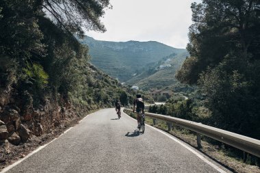 Dağ geçitlerinde iki bisikletçi eğitimi. İspanyol dağlarında bisiklet sürüyor. Kasklı bisikletçiler ve bisiklet giyiyorlar. Liman motivasyonu. Xabia, Alicante, İspanya