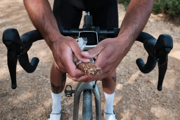 自行车手的运动小吃骑自行车者的运动小吃骑自行车的人手中拿着的运动吧 — 图库照片