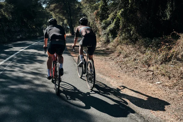 两个骑自行车的人在山路上训练 在西班牙山区骑自行车 骑自行车的人戴头盔和骑自行车 运动动机 骑自行车的专业团体 美丽的风景 西班牙阿利坎特 萨比亚 — 图库照片
