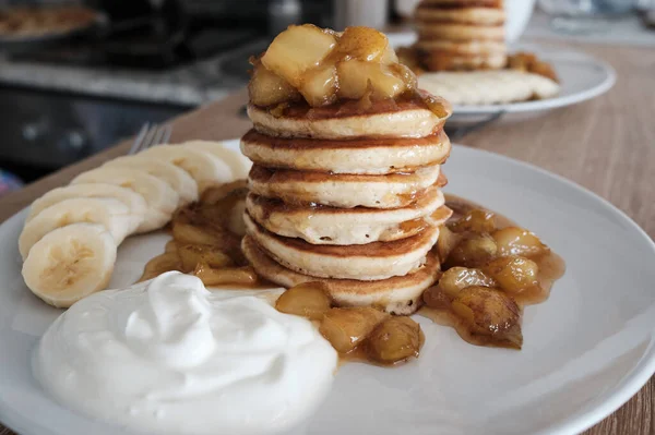 The perfect pancake breakfast.Fluffy pancakes with caramelized pear,yogurt, and bananas.Beautiful healthy breakfast.
